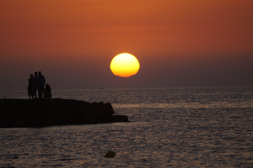 Familie bei Sonnenuntergang am Meer
